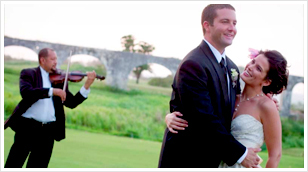 A bride and groom are embraced on in a field